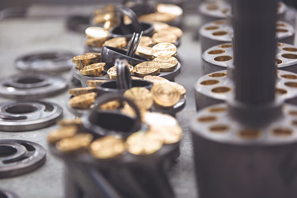 Goudkleurige munten in een industriële machine die ze sorteert of telt.