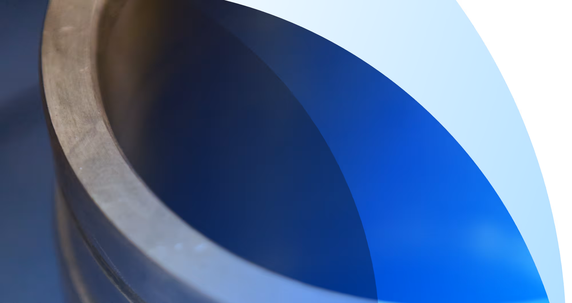 Dichtbijbeeld van de rand en de binnenkant van een metalen cilinder met een blauwe achtergrond.