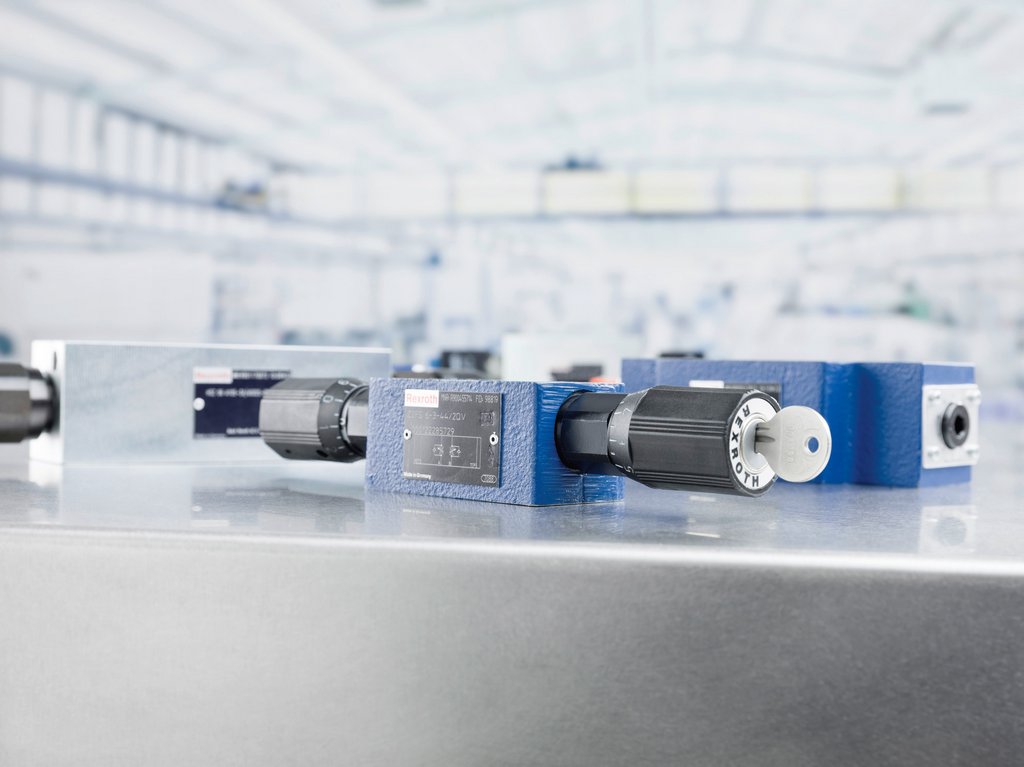 Blauwe en zilveren flow- en gaskleppen op metalen tafel in een lichte industriële ruimte.