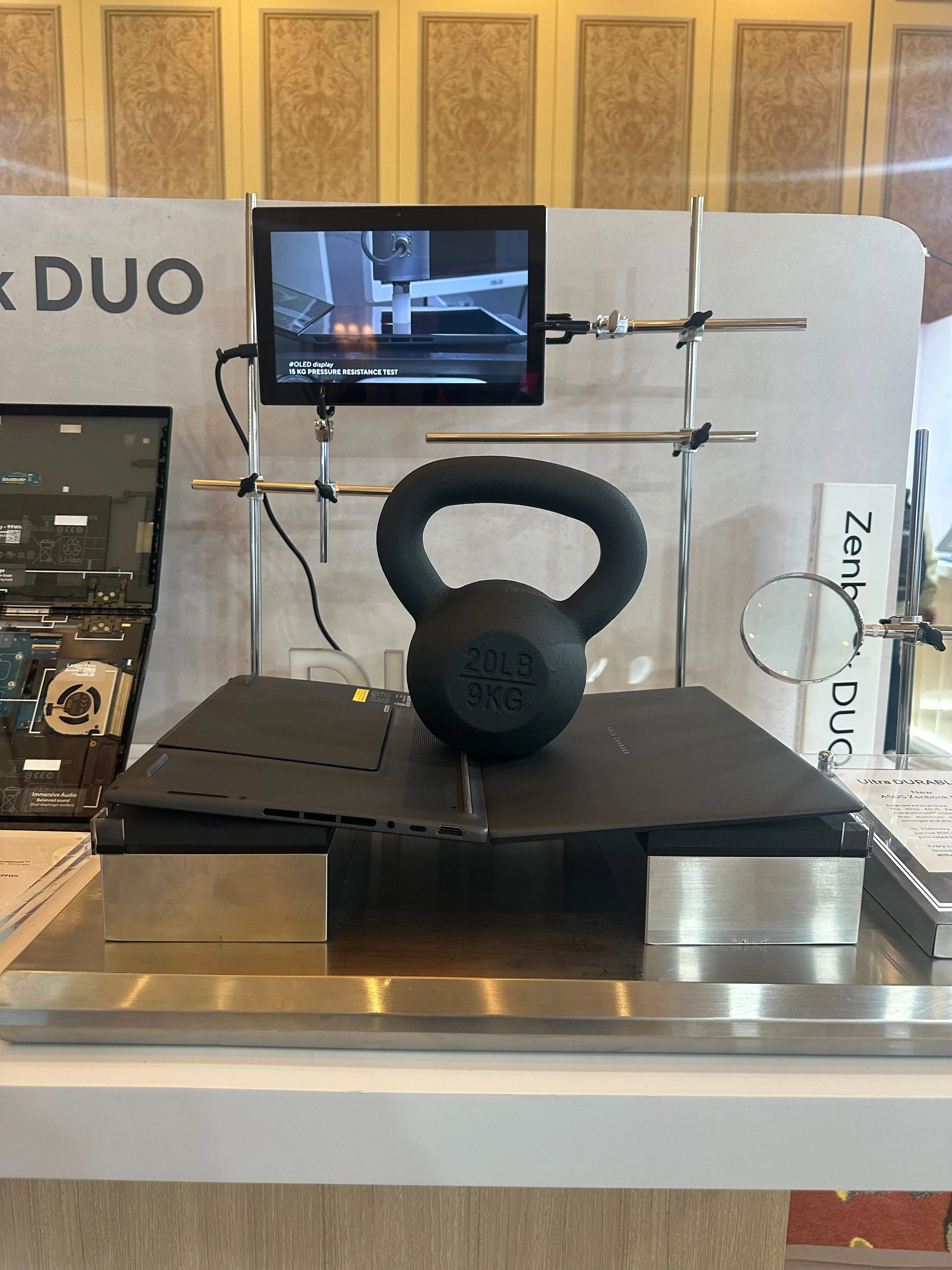 ASUS demonstrating the durability of their product by placing a 20-pound (9-kilo) weight on its hinges