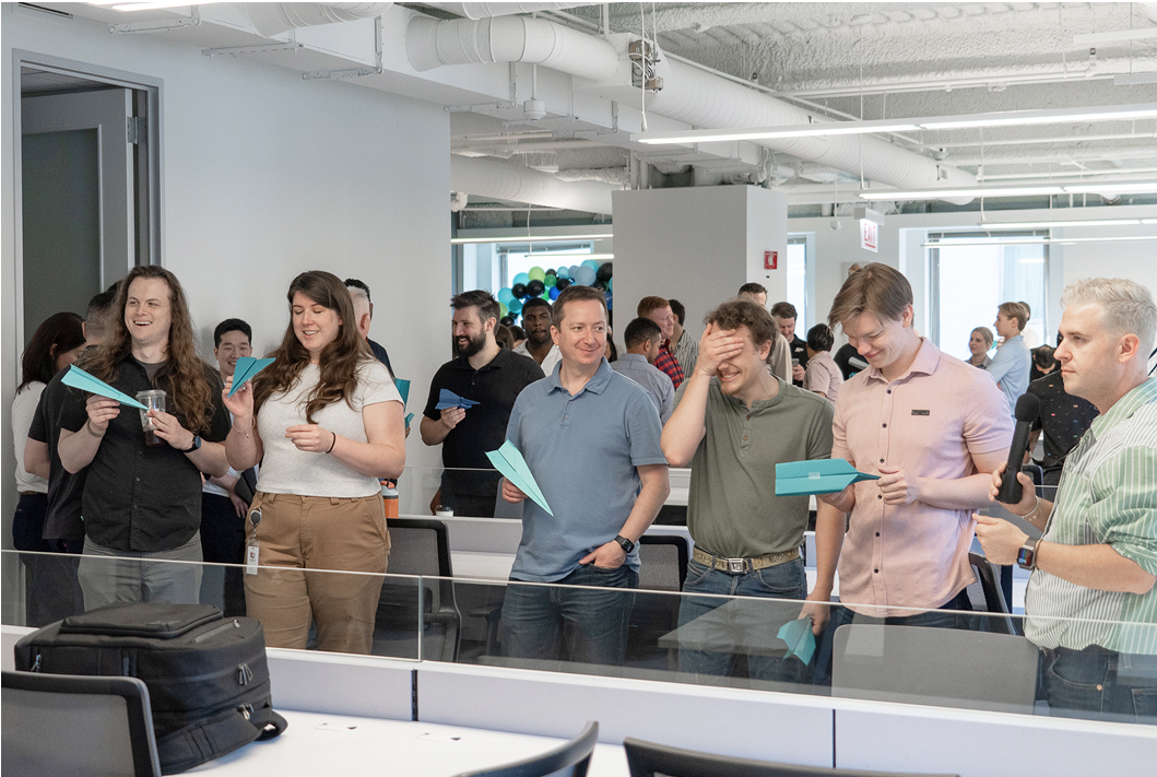 A group of Aeropay employees throwing paper airplanes 