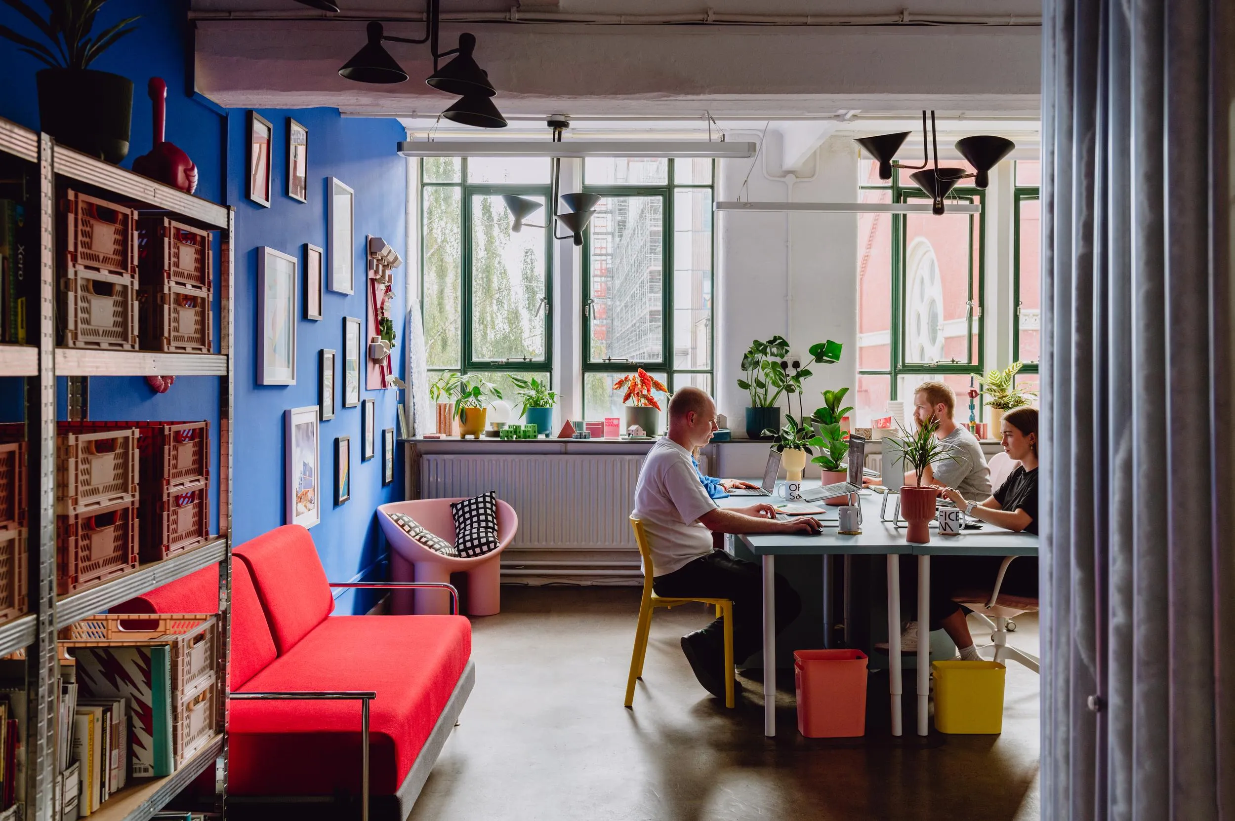 Photo of the space looking towards the windows, with people working at the desks. By Office S&M, RIBA Chartered Architectural Practice in London.