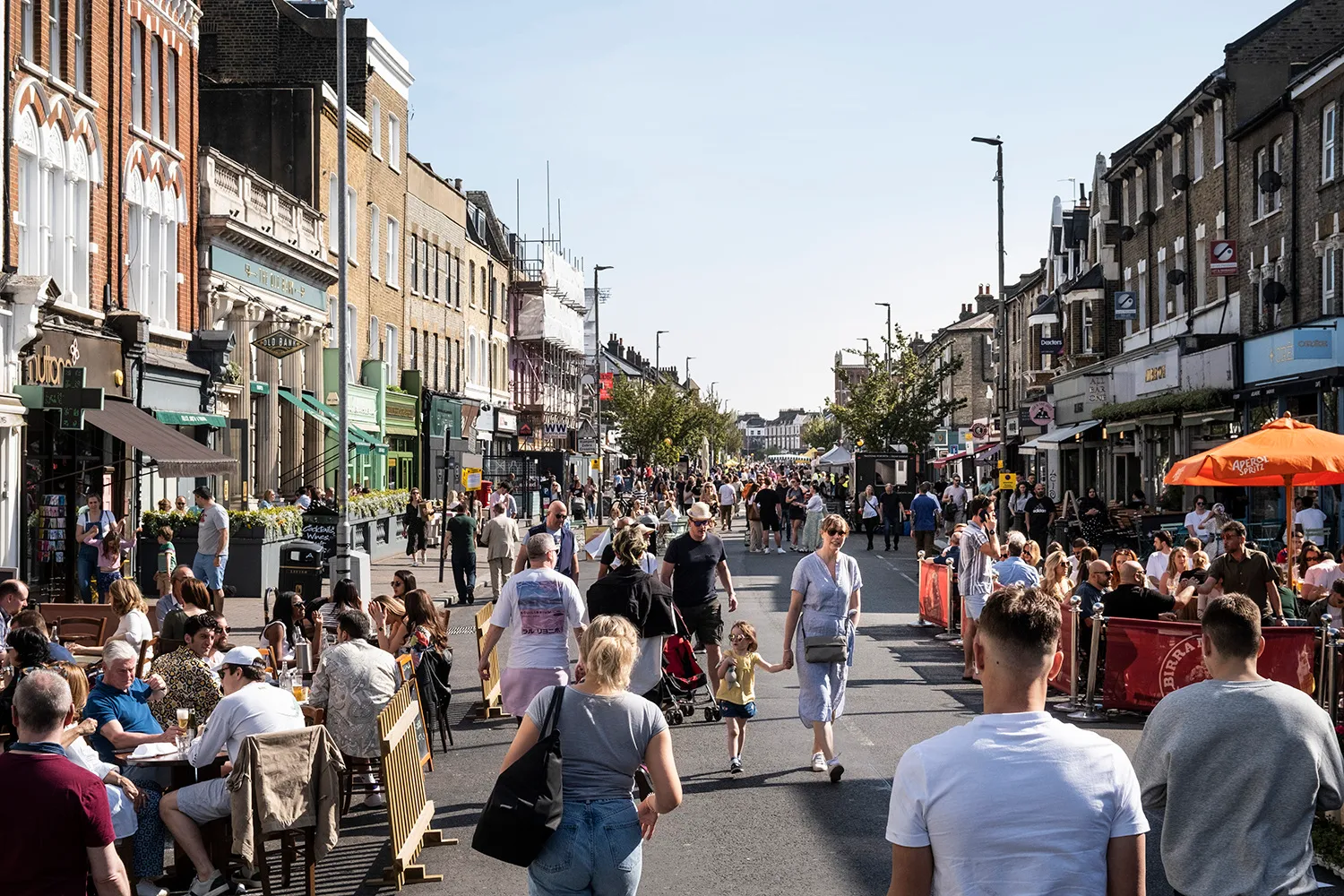 Photo of Clapham Junction High Street, with a crowd of people on a sunny day. By Office S&M, RIBA Chartered Architectural Practice in London.