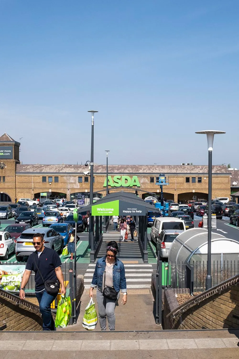 Photo of the parking lot with ASDA shop in the background, showing the connection across the pedestrian bridge. By Office S&M, RIBA Chartered Architectural Practice in London.