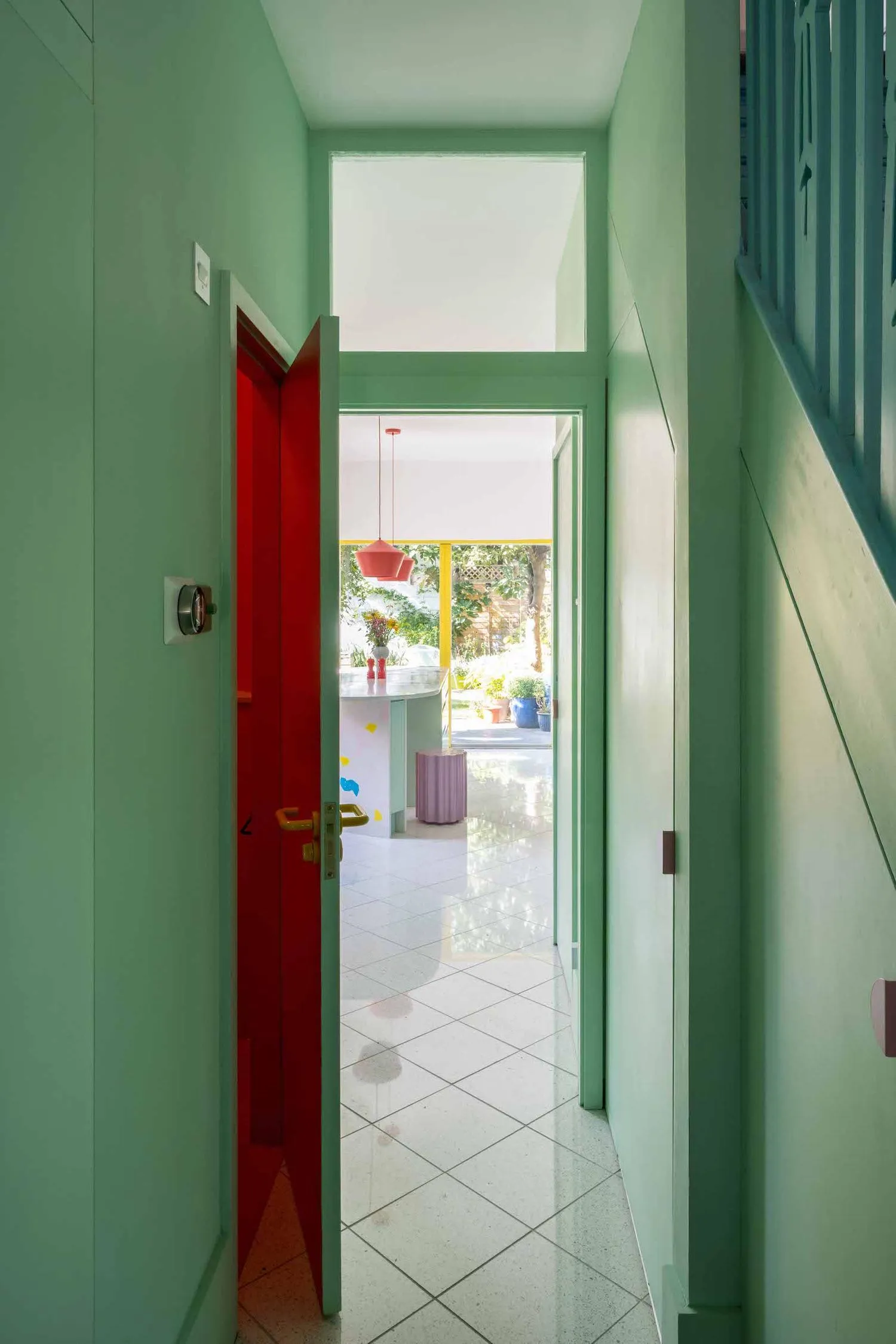 Photo of the green corridor in the house, showing the staircase on the right and entrance to a WC through an ajar door. By Office S&M, RIBA Chartered Architectural Practice in London.