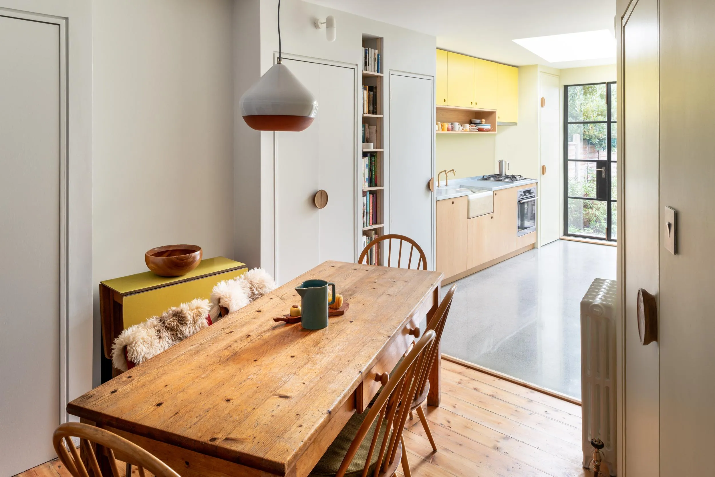 Photo of the dining space, with kitchen and garden in the background. By Office S&M, RIBA Chartered Architectural Practice in London.