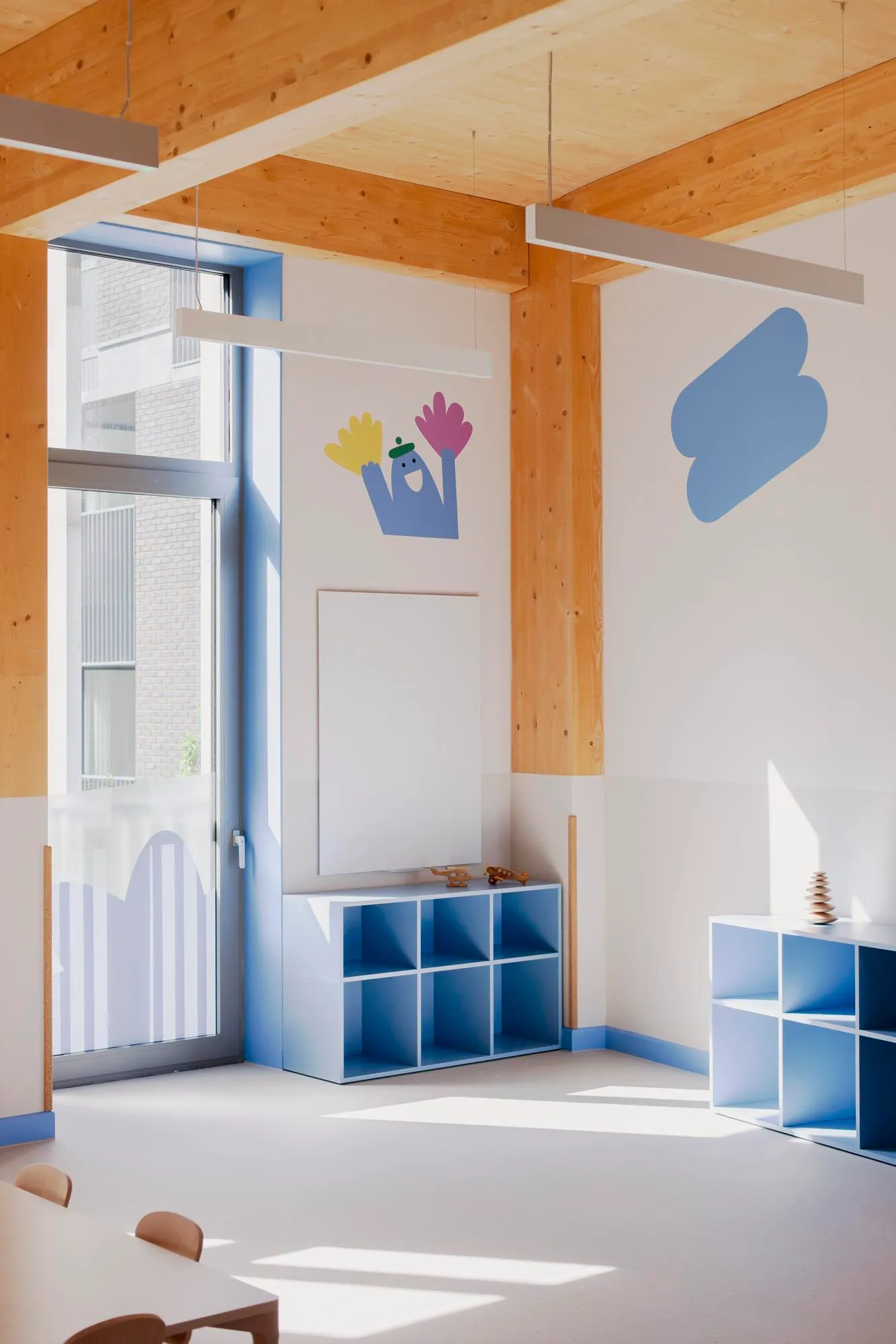 Photo of a play corner with blue furniture and timber structure. By Office S&M, RIBA Chartered Architectural Practice in London.