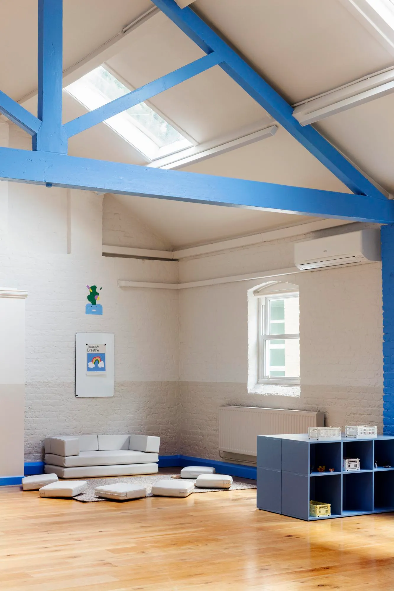Main nursery space, showing the light qualities and blue trusses in the space. By Office S&M, RIBA Chartered Architectural Practice in London.