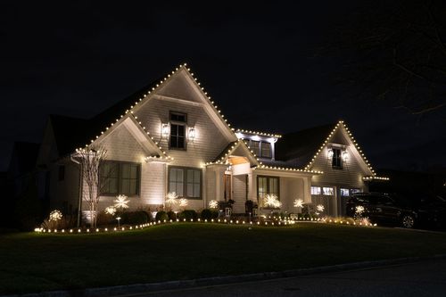 South Jersey home brilliantly lit with festive holiday roofline lights, wrapped tree trunks, and glowing shrubs by LED Elves®