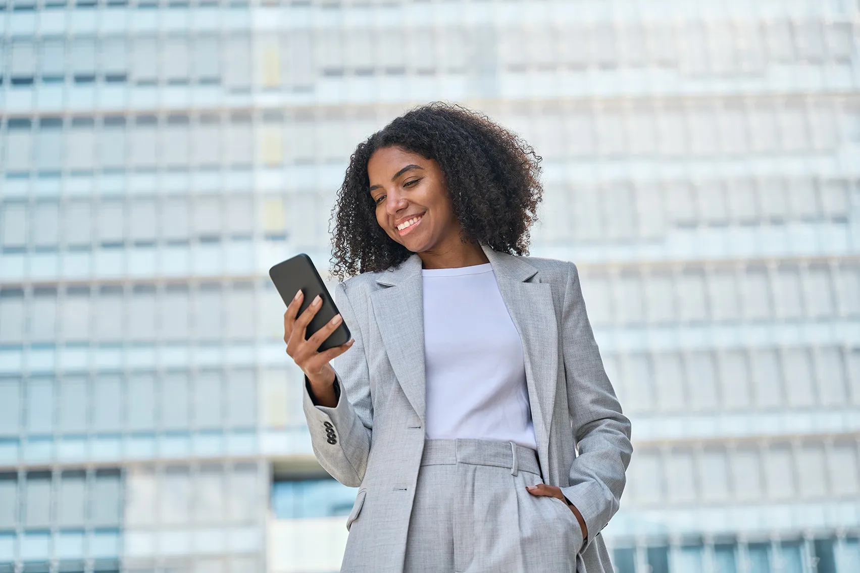 Young business-woman smiling and looking at her phone