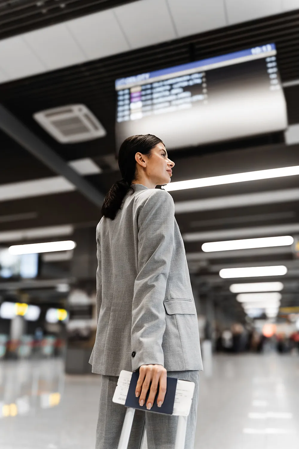 Business woman walking with her suitcase in an airport