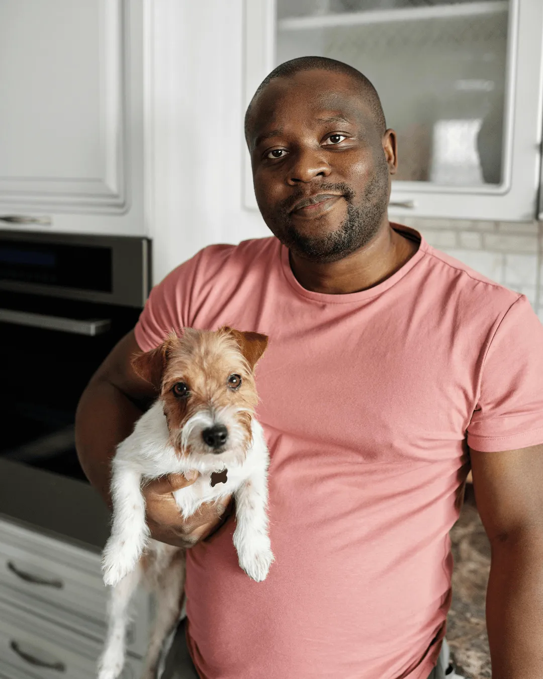 photo of a man holding a small dog 