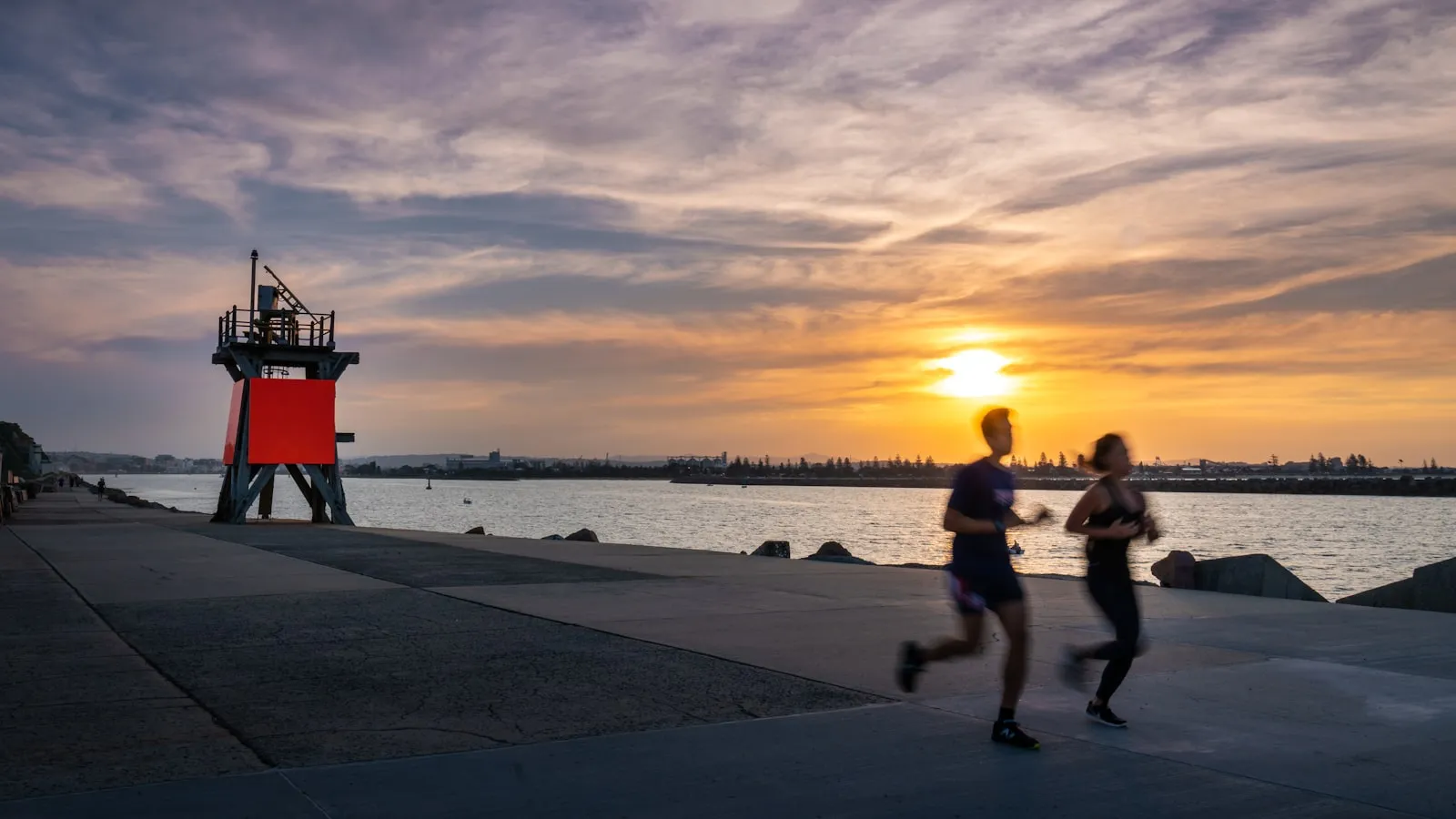 Two people jogging at sunrise