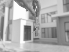 real estate litigation hand holding keys in front of a house