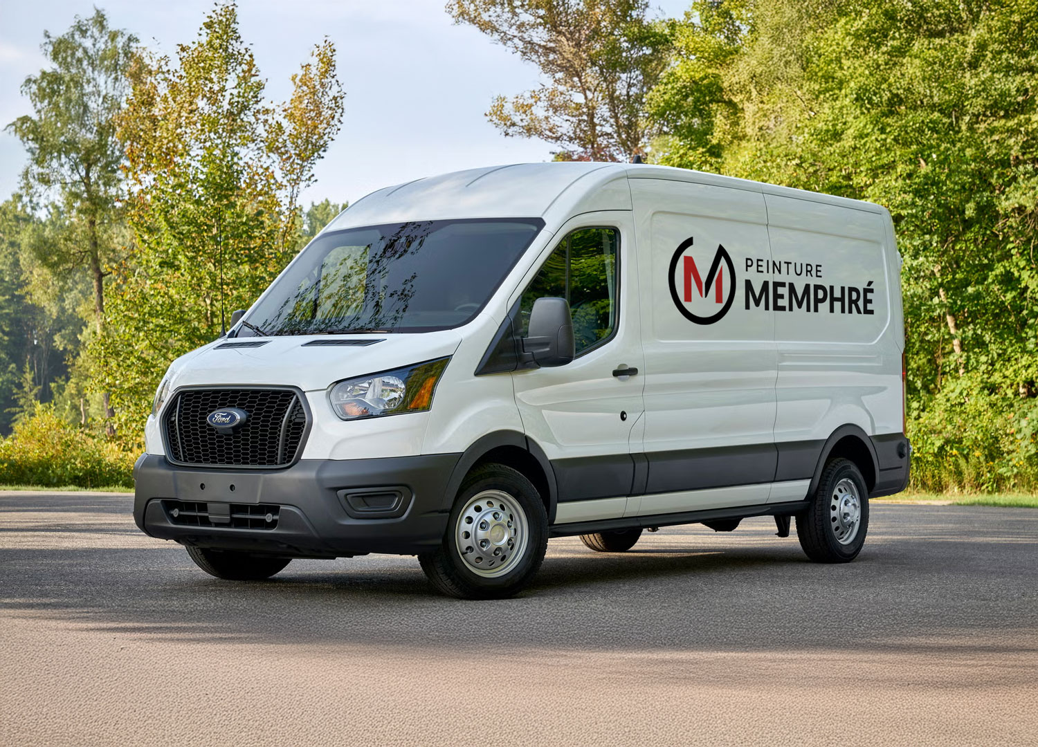 Véhicule utilitaire blanc Ford avec le logo et le texte Peinture Memphré sur le côté, stationné devant des arbres verts.