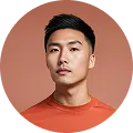 Portrait d'un homme en t-shirt orange sur fond terracotta