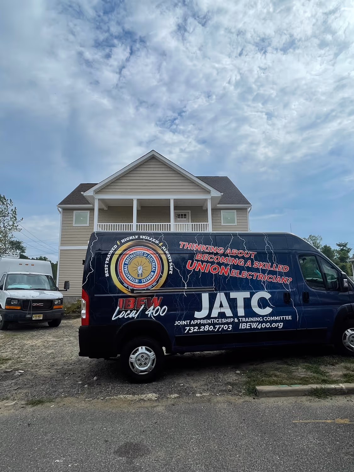 Blue van parked in front of a beige two-story house with text promoting skilled union electricians and apprenticeship training.