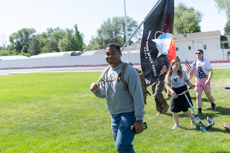Man carries United States Space Force flag at outdoor community event