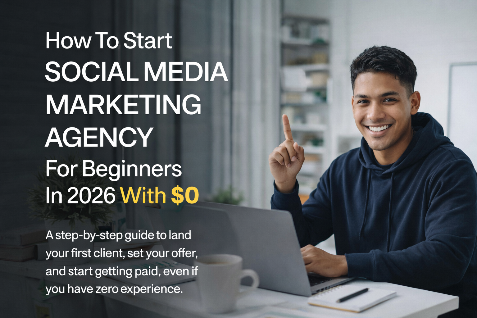 Smiling young man in a navy hoodie sitting at a desk with a laptop, pointing up, next to text about starting a social media marketing agency for beginners with no cost in 2026.