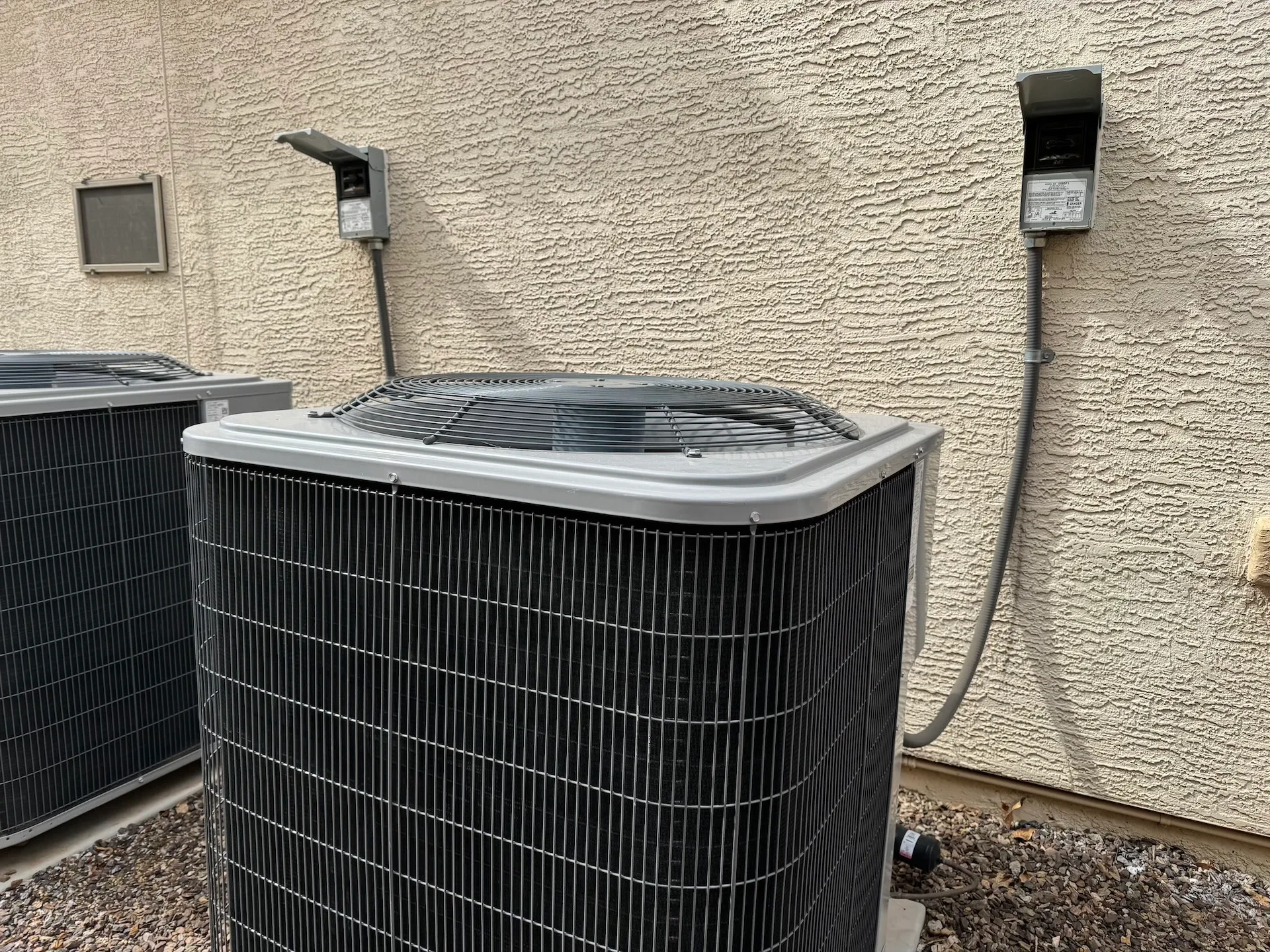 two ac condenser units on side of house