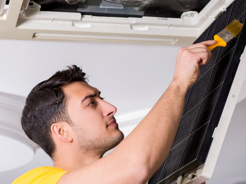 a man cleans an ac air filter