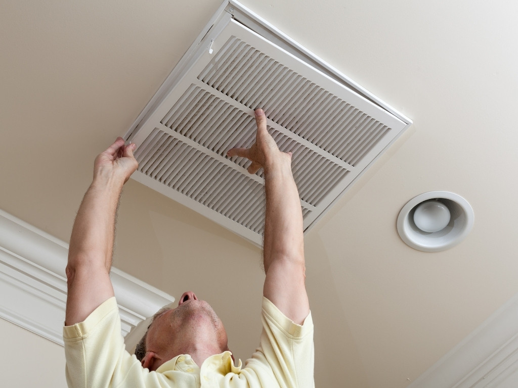 an ac technician replacing an air filter