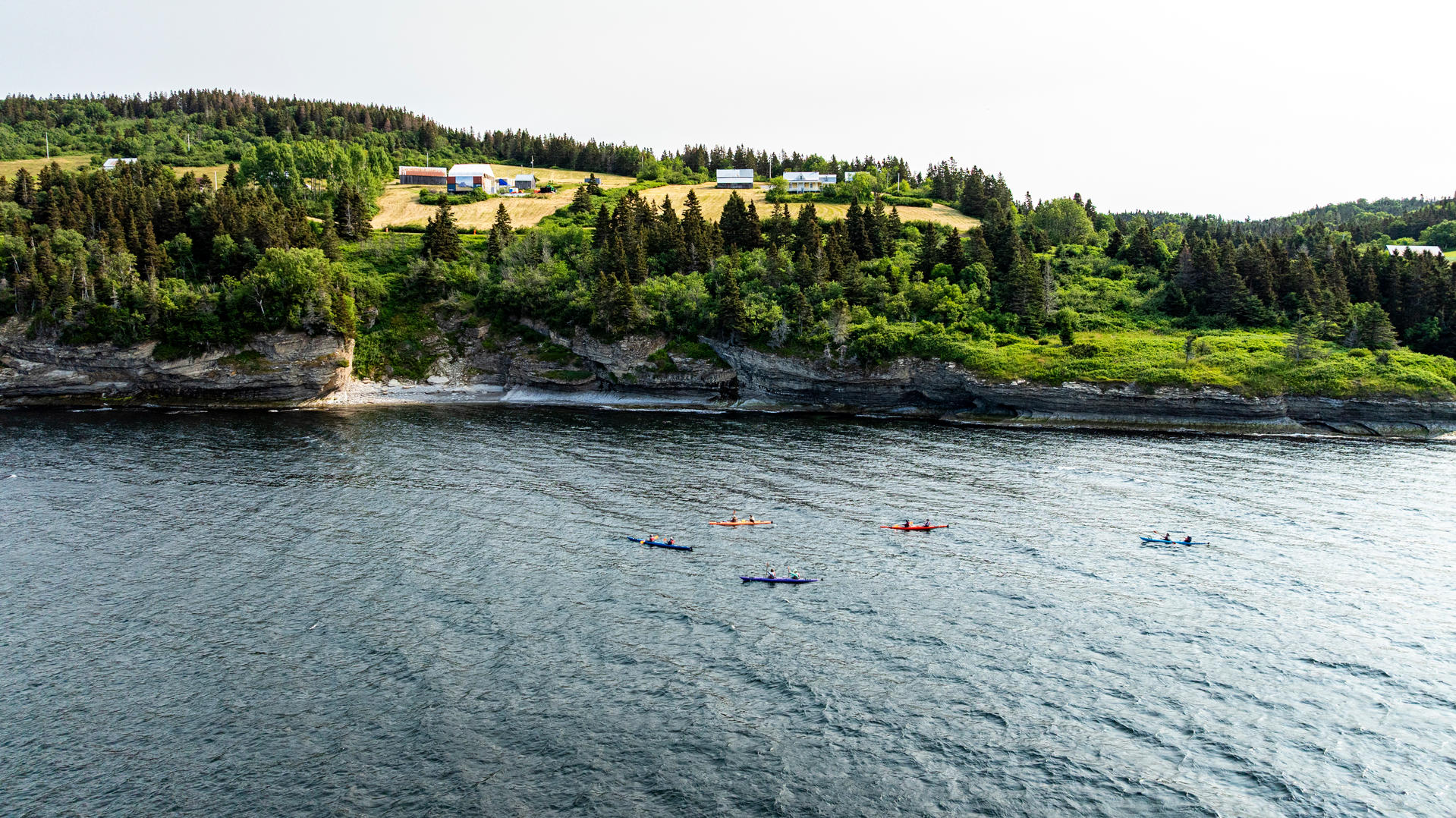Kayaks de mer longeant les falaises du parc national Forillon dans la baie de Gaspé.