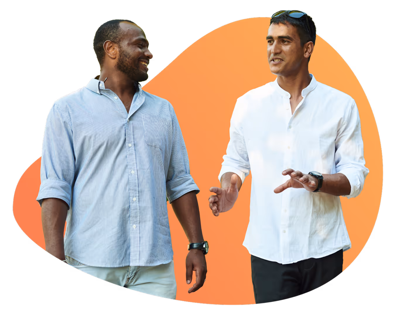 Two men smiling and talking, one wearing a light blue shirt and the other a white shirt with sunglasses on his head.