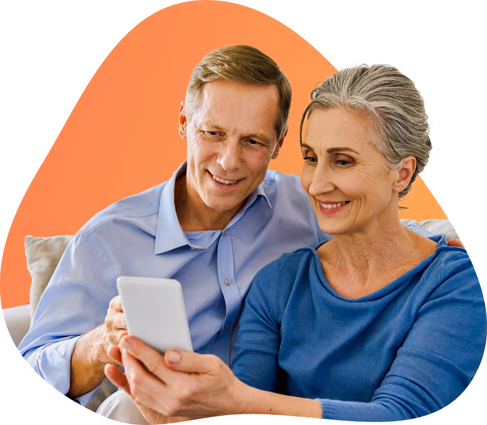 Smiling middle-aged couple sitting together and looking at a smartphone.