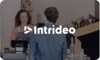 Customer facing a cashier at a counter with Intrideo logo overlayed.