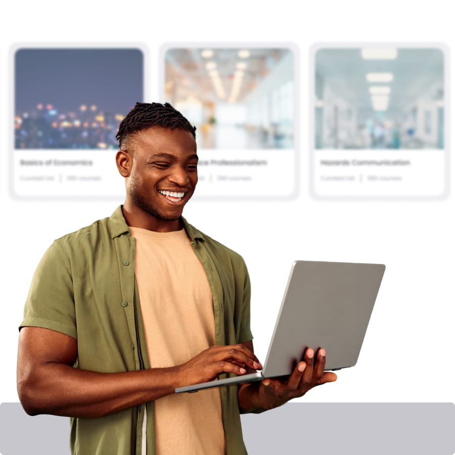 Smiling professional holding a laptop in front of a row of course cards