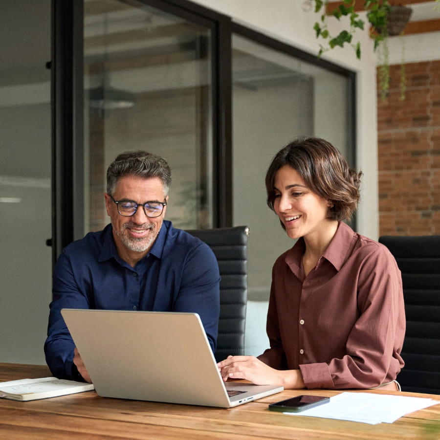 Two curators reviewing training options together on a laptop