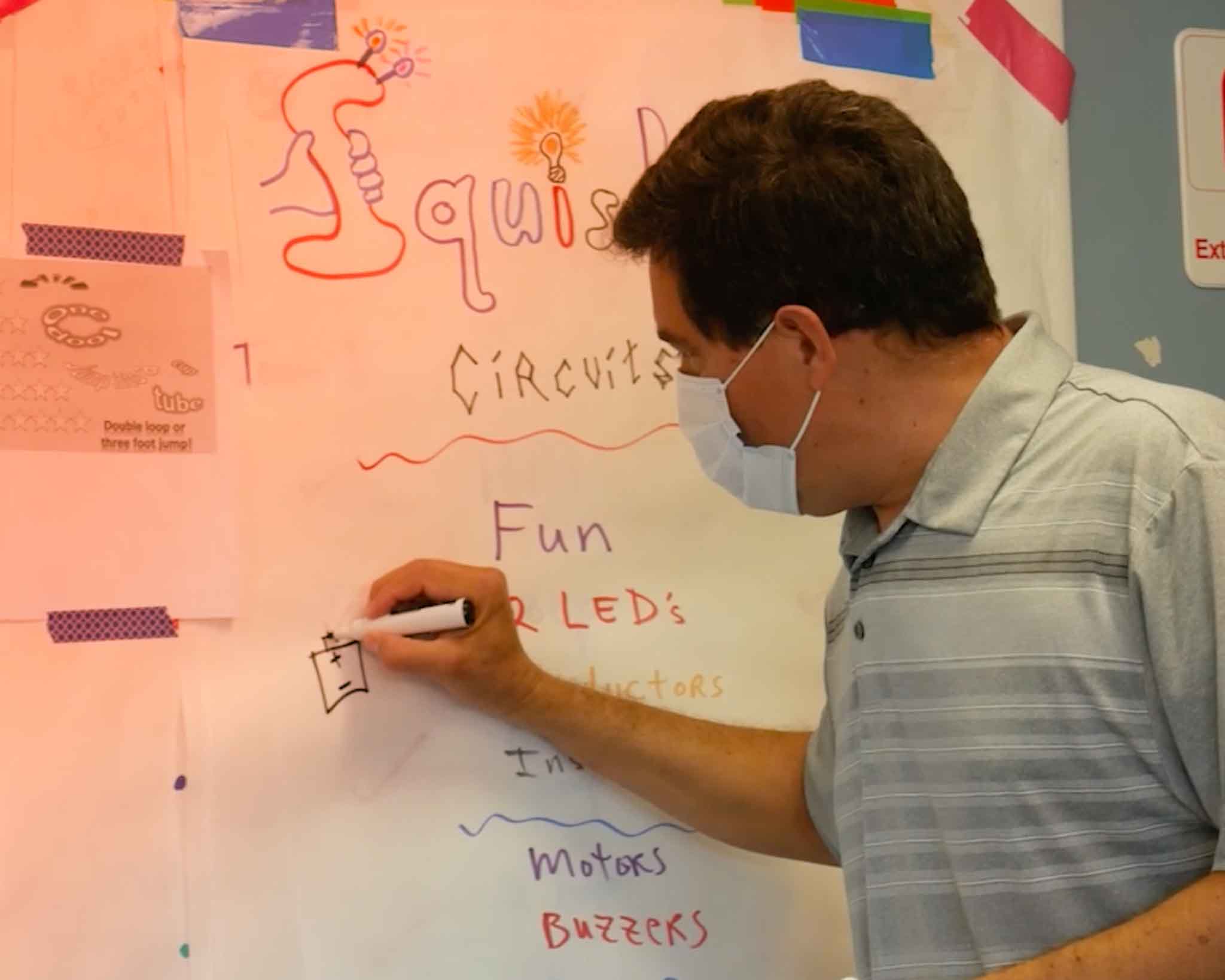 Teacher explaining how to wire electronics