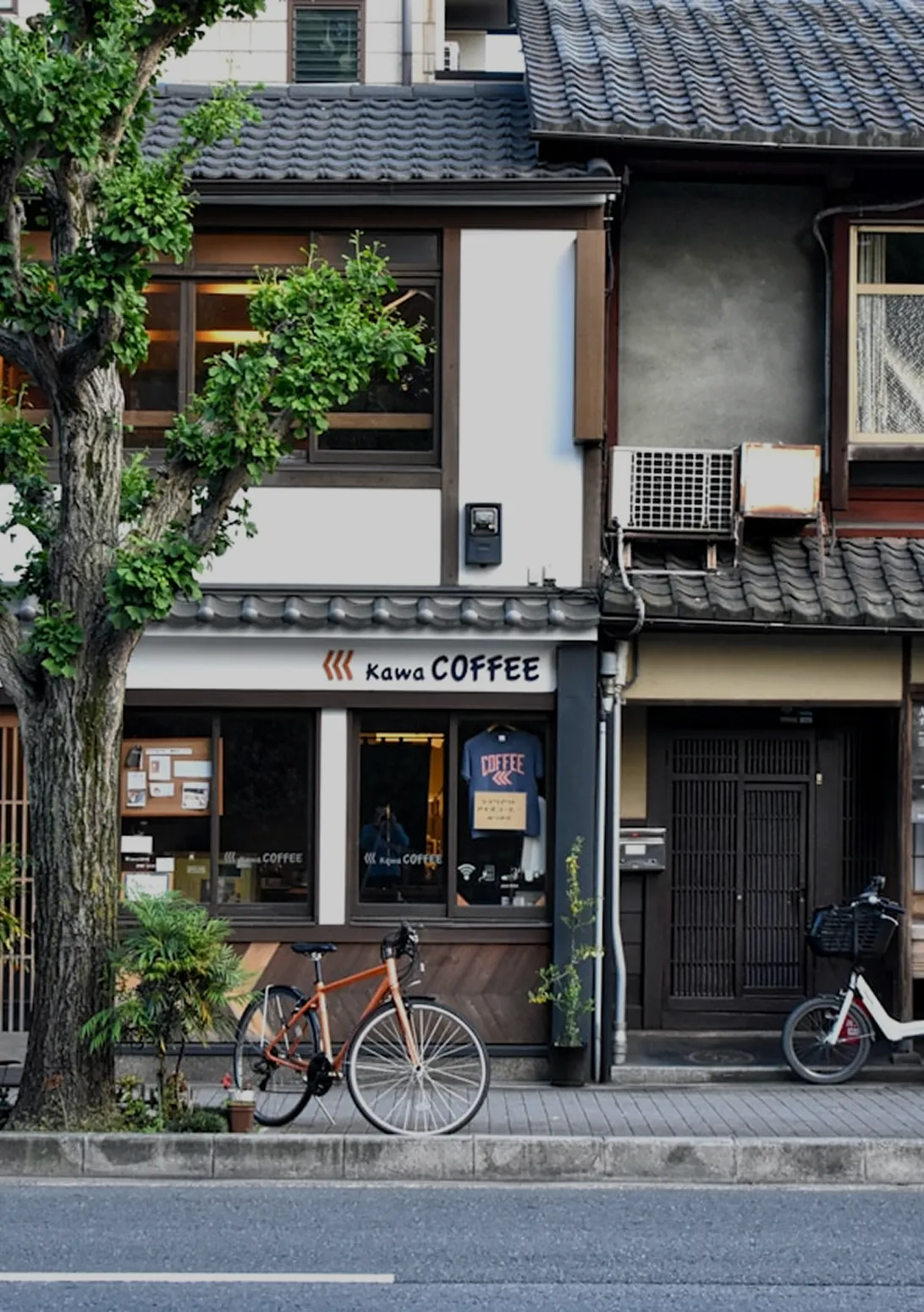 Street view of a cozy Japanese coffee shop with bicycles outside.