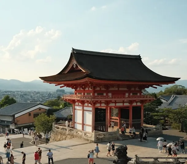 A scenic Japanese temple with tourists walking around.