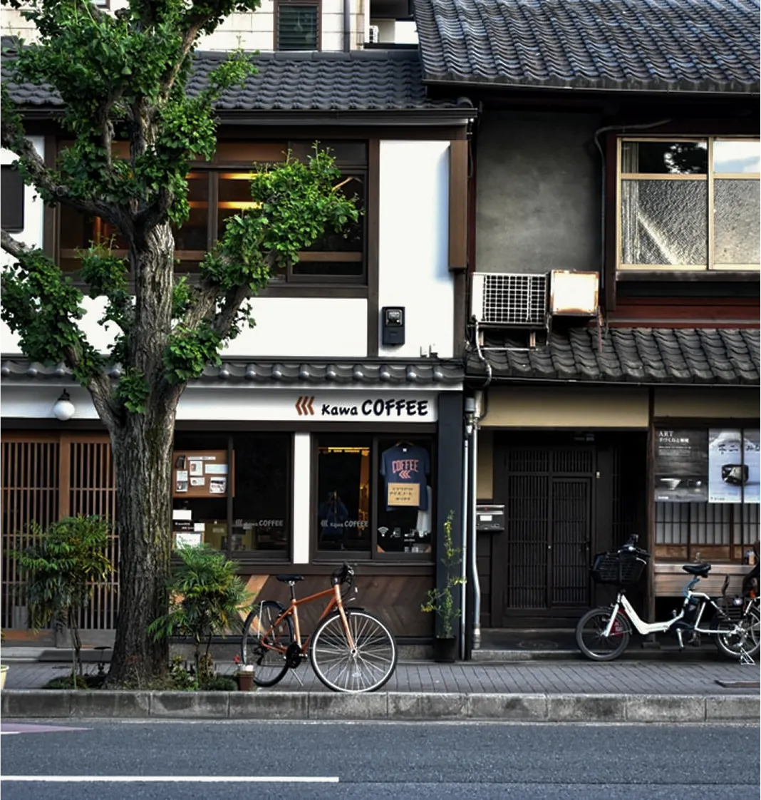 A coffee shop facade in a traditional Japanese street, with a bicycle parked outside.