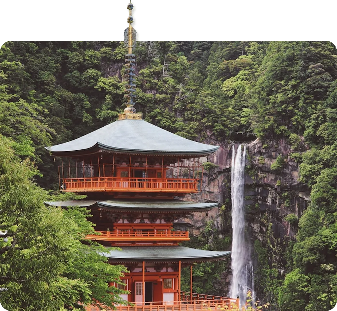 Japanese pagoda next to a waterfall.