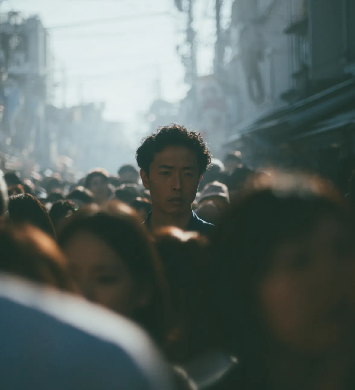 Man standing in a crowded street with blurred people around him