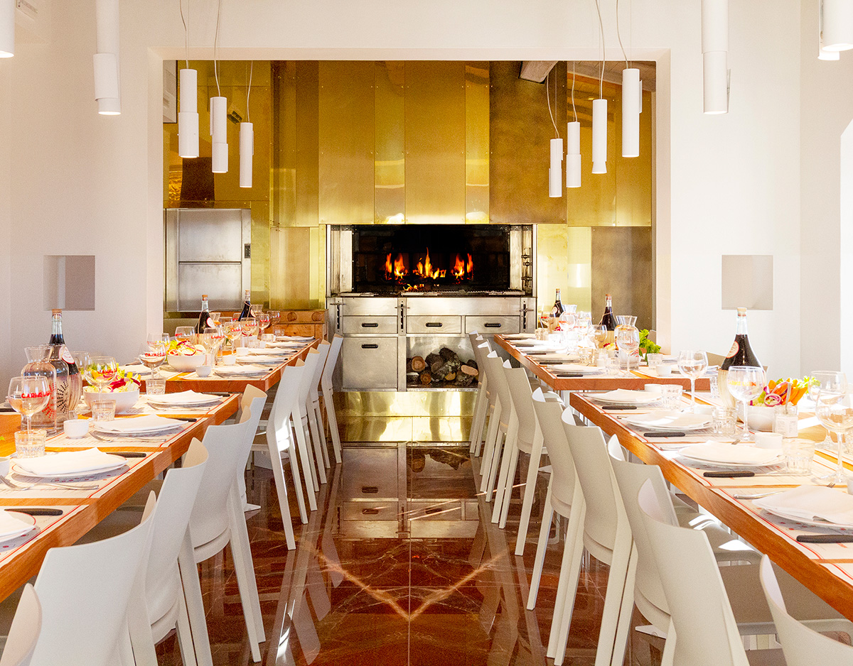 Long communal table at Officina della Bistecca where guests dine together family-style.