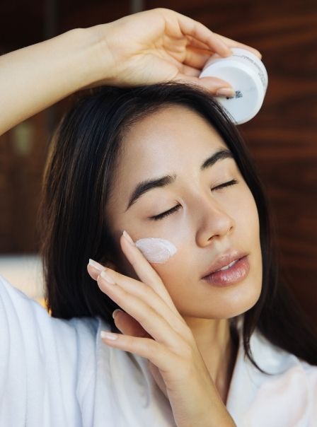 Femme appliquant de la crème au Grand Hôtel de Courtoisville à Saint-Malo, spa bien-être et soins beauté.