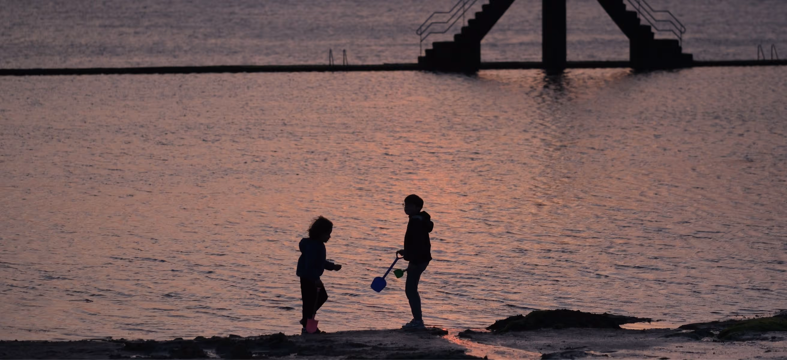 Famille en bord de mer au coucher de soleil à Saint-Malo près du Grand Hôtel de Courtoisville, hôtel spa 4 étoiles en Bretagne.