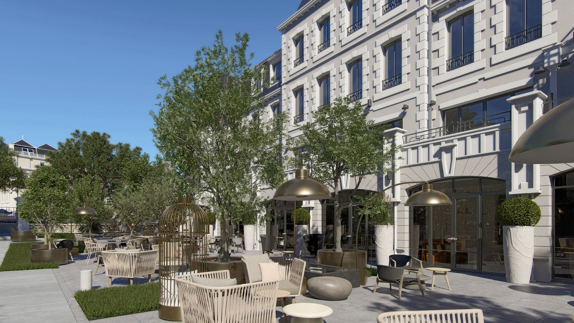 Façade avec terrasse aménagée et fauteuils du Grand Hôtel de Courtoisville à Saint-Malo, hôtel spa 4 étoiles en bord de mer.