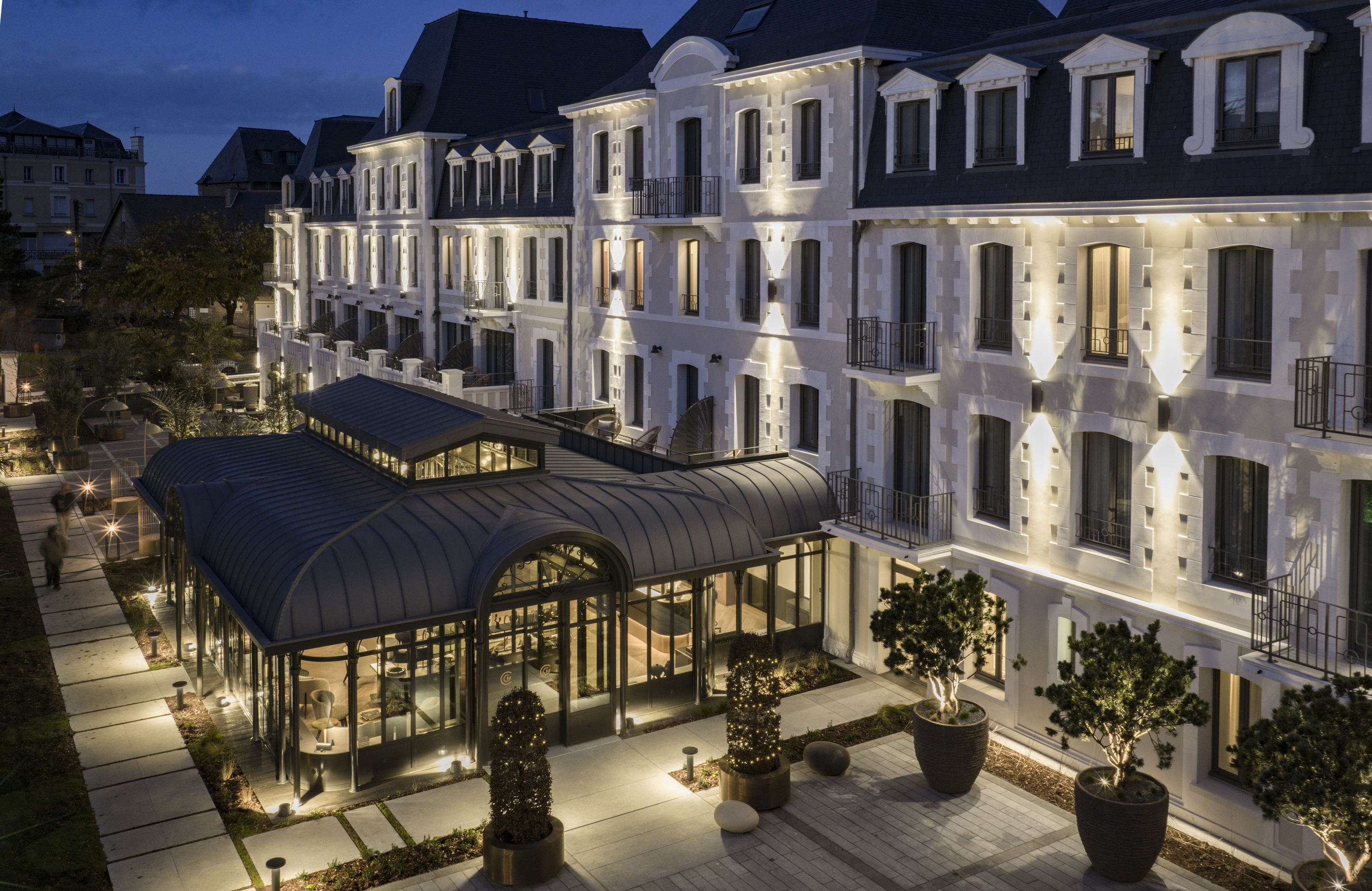 Entrance with gate and facade of the Grand Hotel de Courtoisville in Saint-Malo, a 4-star spa hotel on the beach.