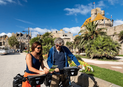 Two tourists with their bikes looking at a map of the city