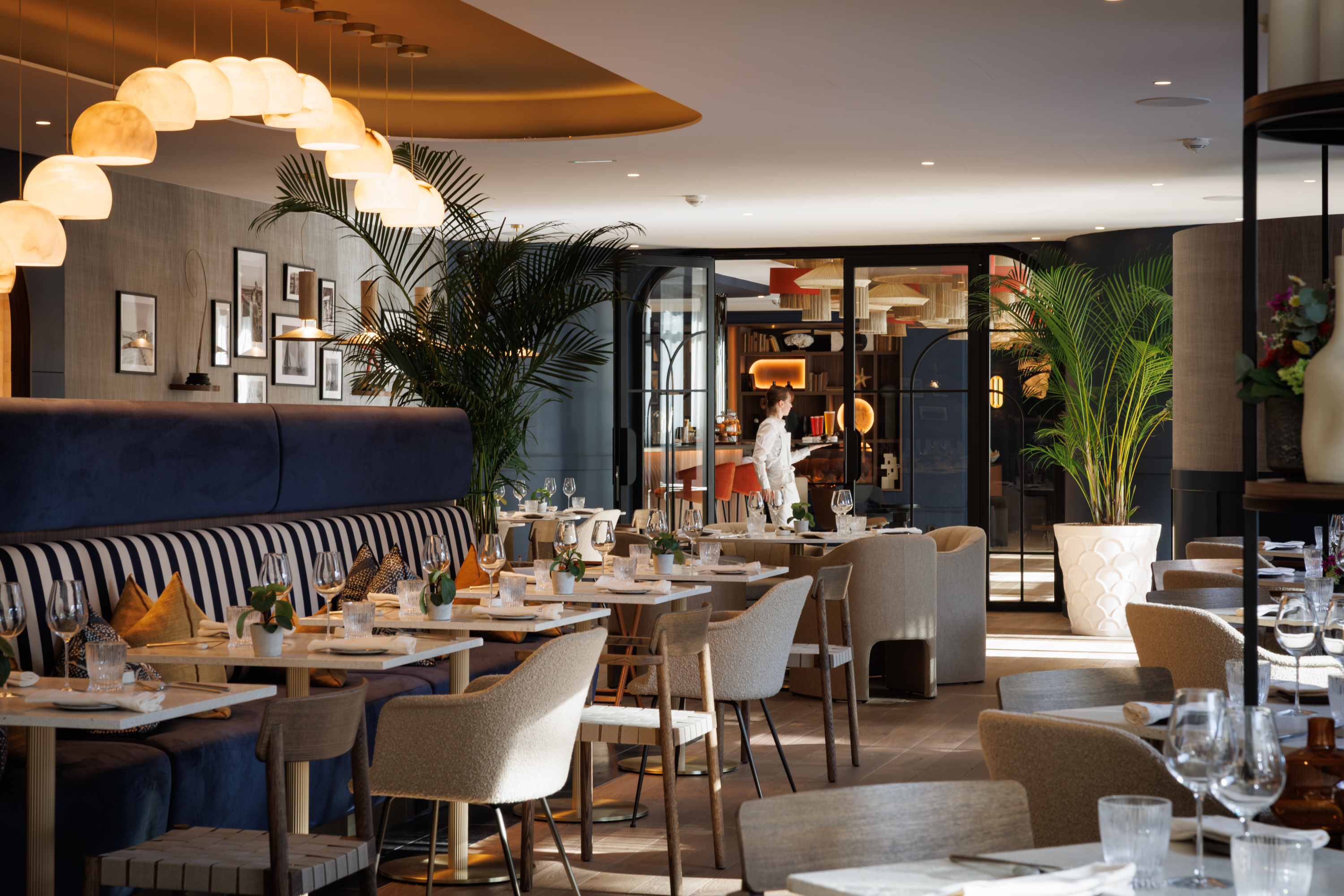Salle du restaurant élégamment dressée au Grand Hôtel de Courtoisville à Saint-Malo, hôtel 4 étoiles de luxe.