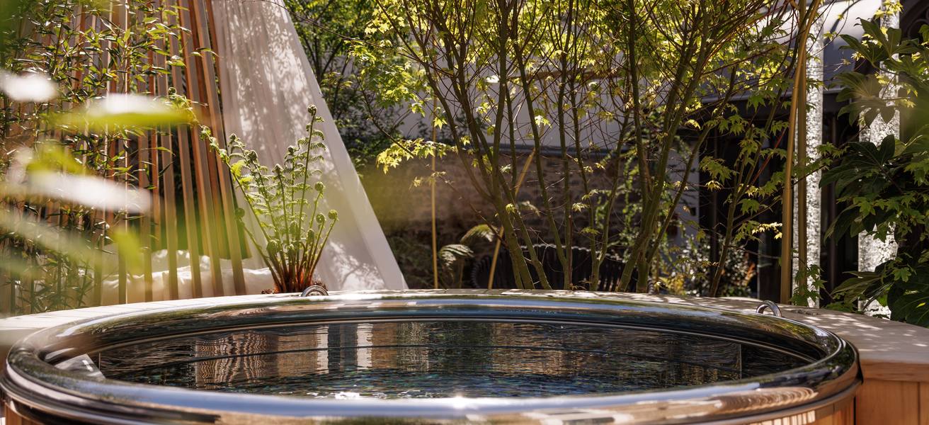 Spa rond en bois avec vue miroir installé dans le jardin arboré de Courtoisville, en Bretagne