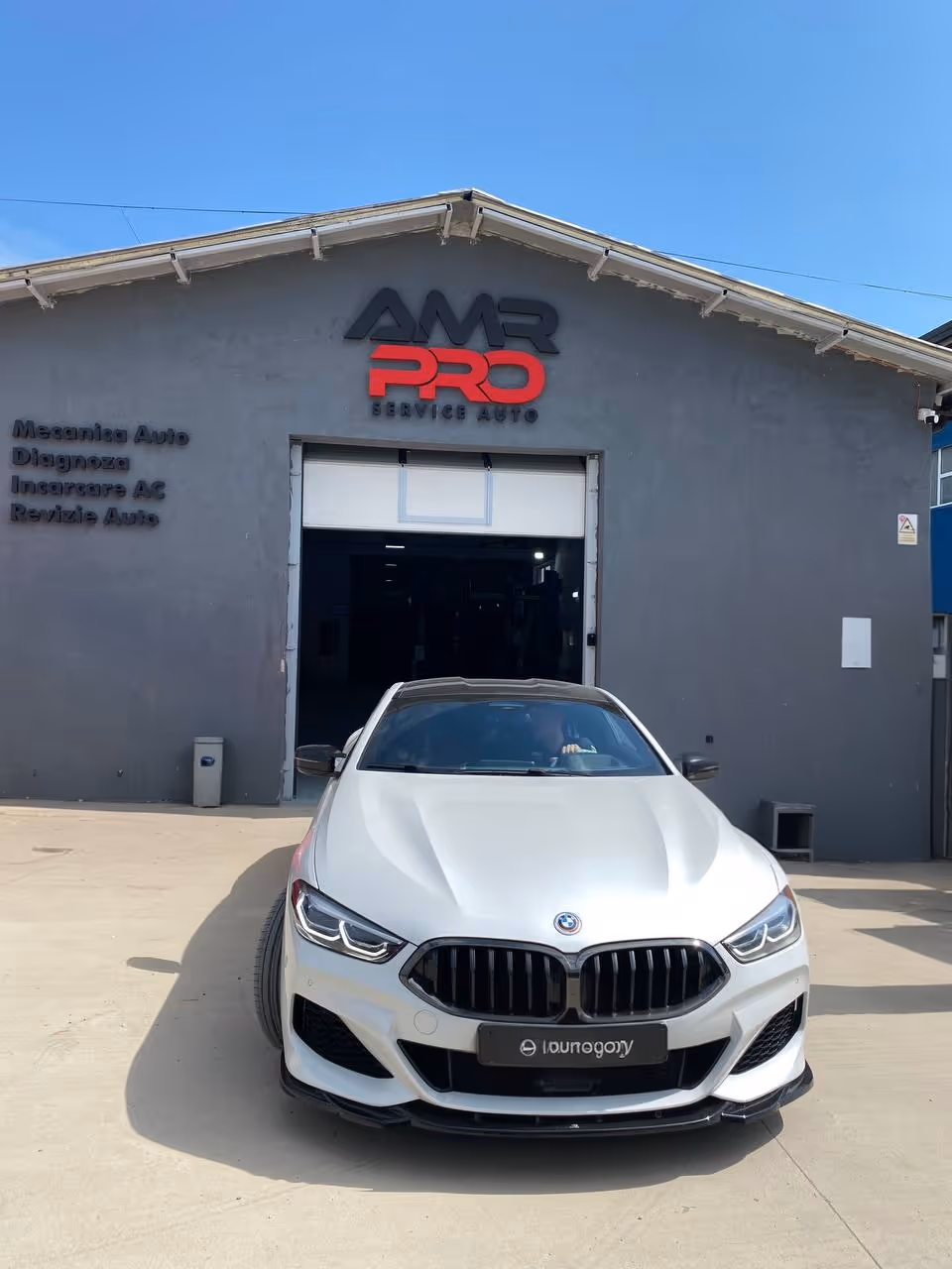 BMW M750 alb în fața service-ului auto AMR PRO