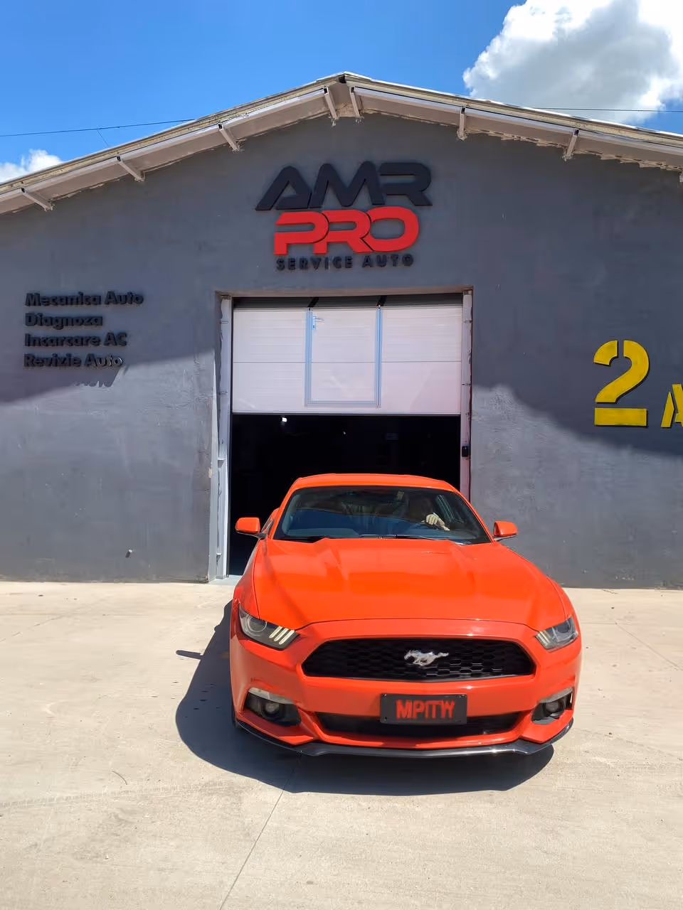Ford Mustang roșu în fața service-ului auto AMR PRO