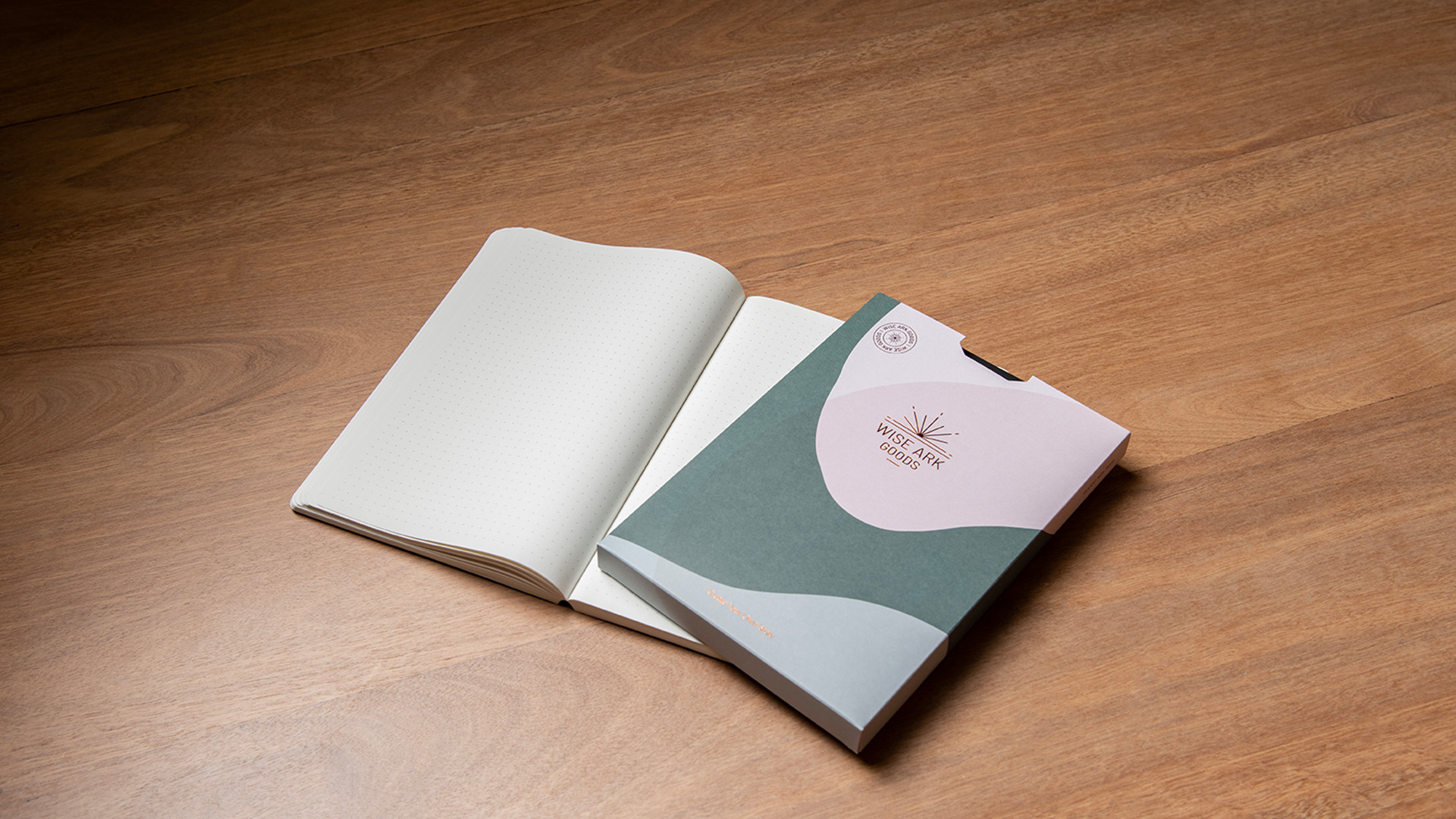 notebook opened up on a wooden table top with sleeve