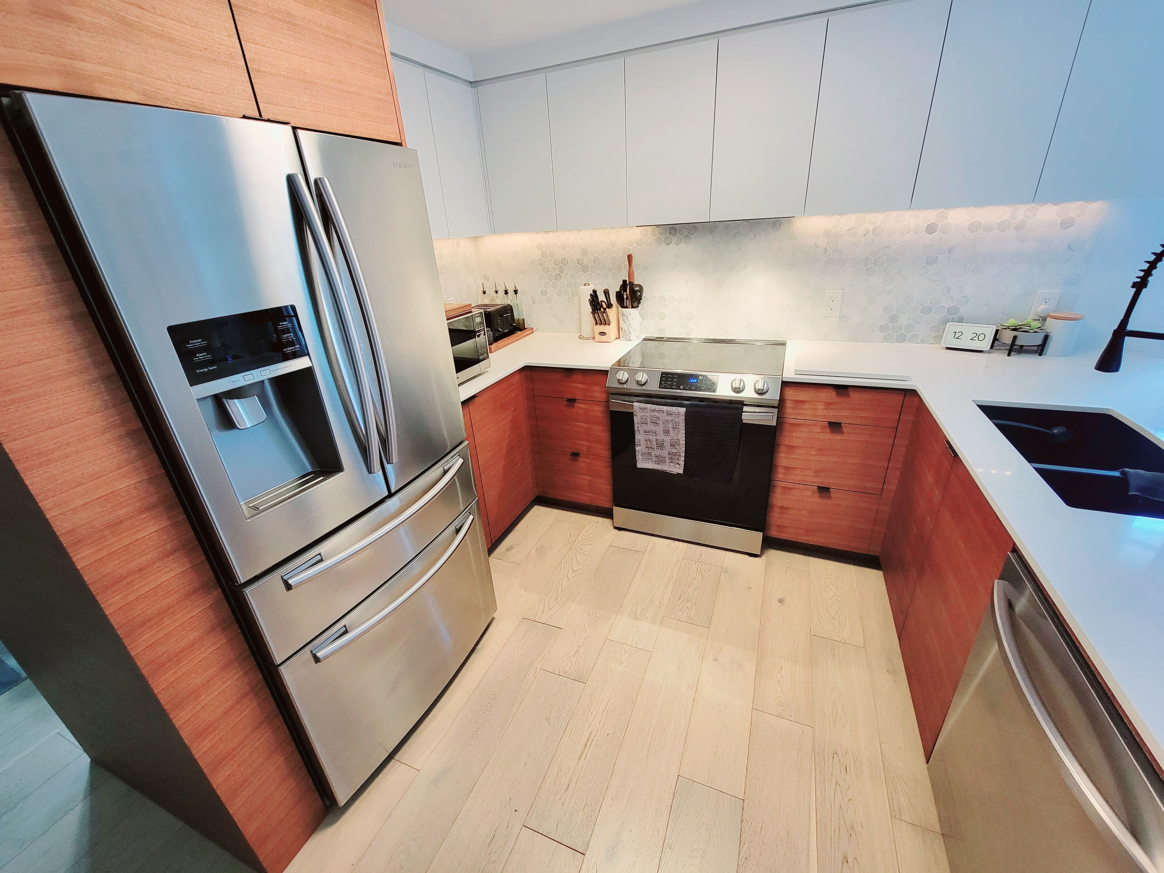 Custom walnut kitchen island with modern design and integrated storage in a Kitchener, Ontario home by Goosen Inc.